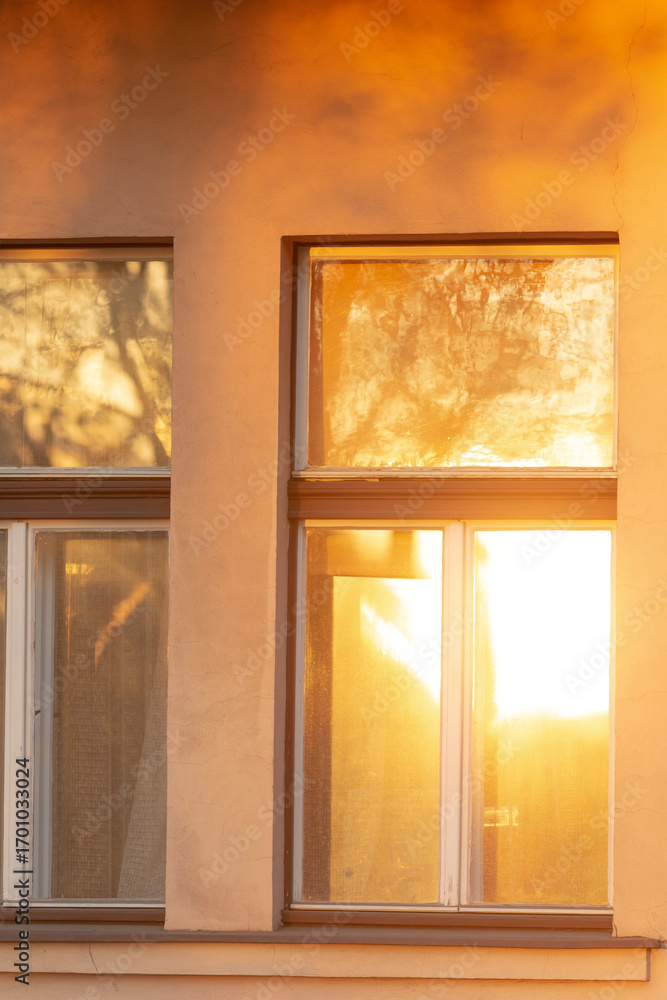 Fototapeta premium A breathtaking view of windows reflecting the warm sunset light, highlighting the interplay of light and shadows on a buildings facade, creating an unforgettable visual experience