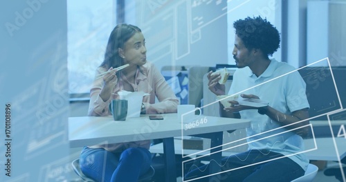 Talking coworkers using chopsticks and eating sandwich at office lunch table, with mug smartphone