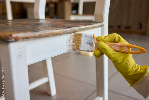 Photography Engage in DIY chair restoration using a paint brush and protective gloves for th