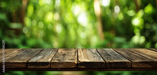 Rustic wooden table top against a blurred green forest backdrop