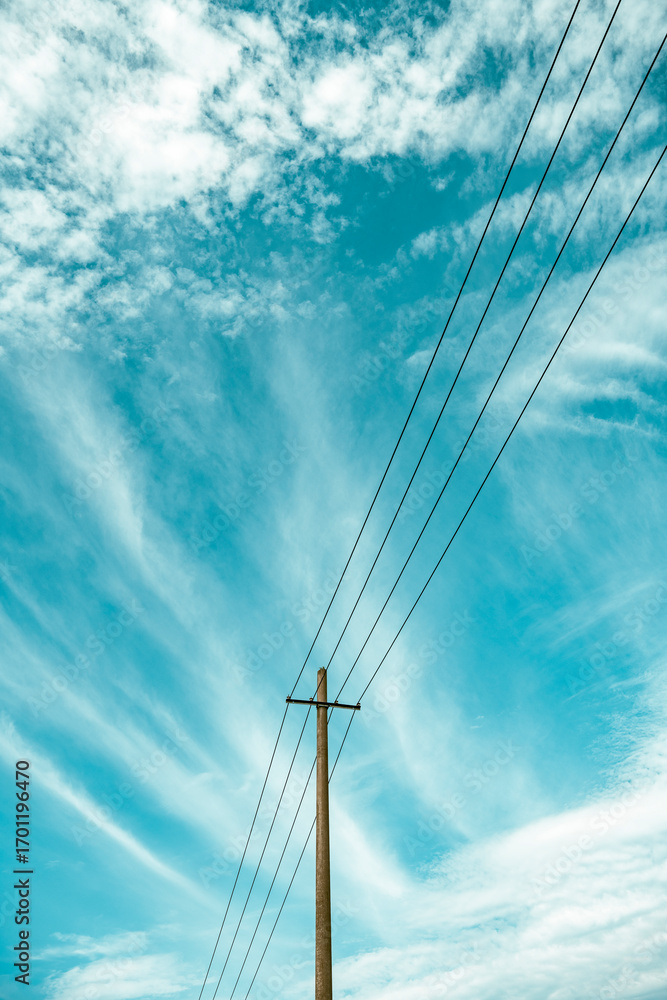 Obraz premium Telephone poles and wires under the blue sky