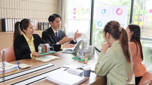 Asian real estate businessmen and home sales agents meet with clients and introduce new home models to Asian buyers investing in real estate business concepts.VDO Slow Motion