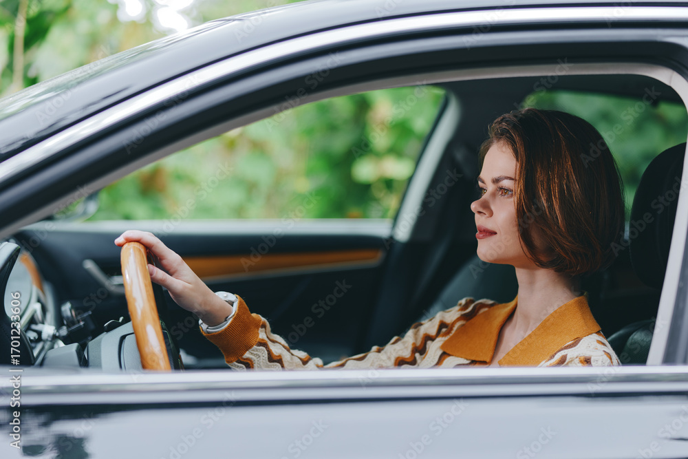 Naklejka premium A focused woman drives a car, hands on the wheel, eyes ahead, wearing a warm sweater, with a calm interior and soft natural light highlighting concentration and independence.
