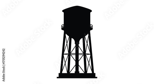 a tall water tower stands against clear sky silhouette