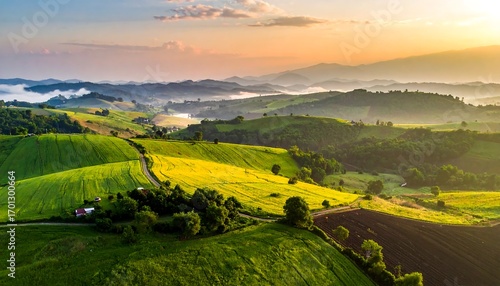 A breathtaking vista of rolling hills, vibrant green fields, and golden crops, bathed in the soft light of a sunrise.