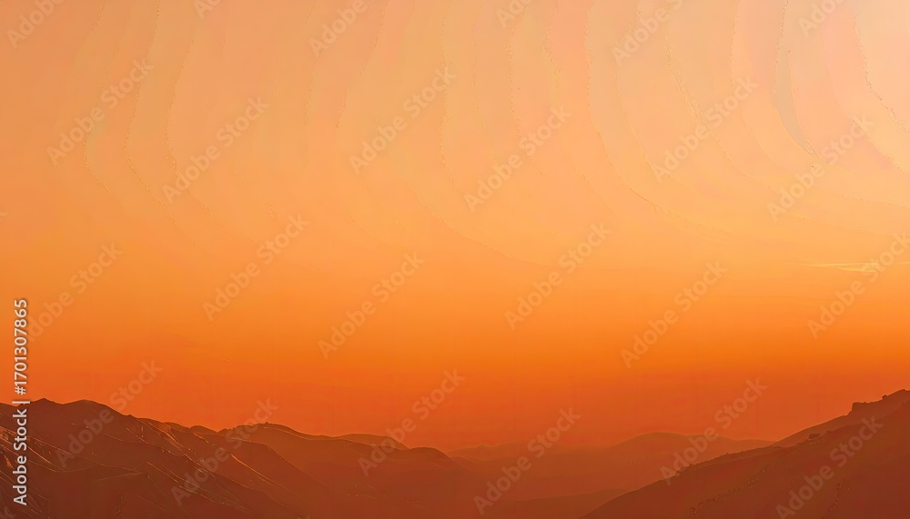 Obraz premium Orange Sunset Over Silhouetted Mountains