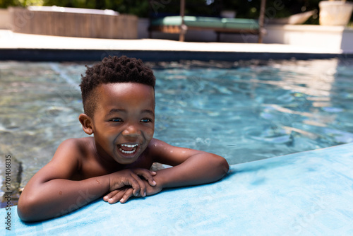 Canvastavla Smiling African American boy enjoying swimming in pool on sunny day