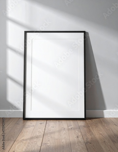 Black Frame Mockup Leaning Against Gray Wall on Wood Floor with Sunlight