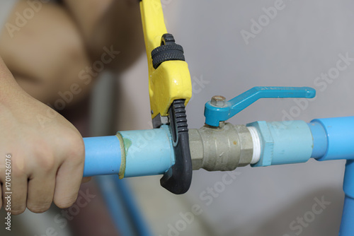 Papier peint Plumber using a wrench to repair a water pipe