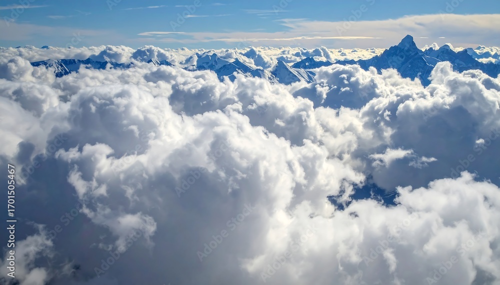 Fototapeta premium A breathtaking vista of snow-capped mountain peaks piercing through a dense field of puffy white clouds, viewed from an elevated perspective.