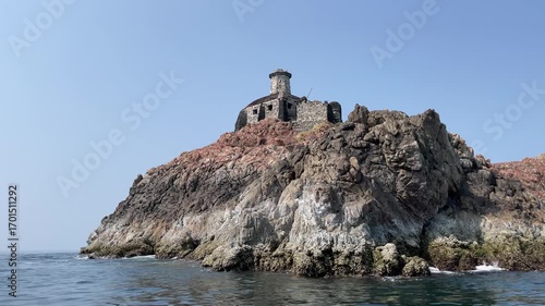 Abandoned Lighthouse on rock in ocean