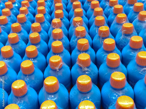 Rows of white plastic bottles with caps, perfect for concepts like cleaning products, consumer goods, and industrial supplies.