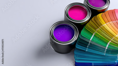Open paint cans with purple and pink paint and colorful paint swatch fan on white surface with shadow