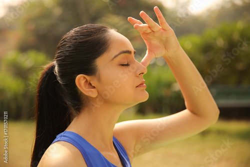 Girl Practicing Deep Breathing Exercise In Park