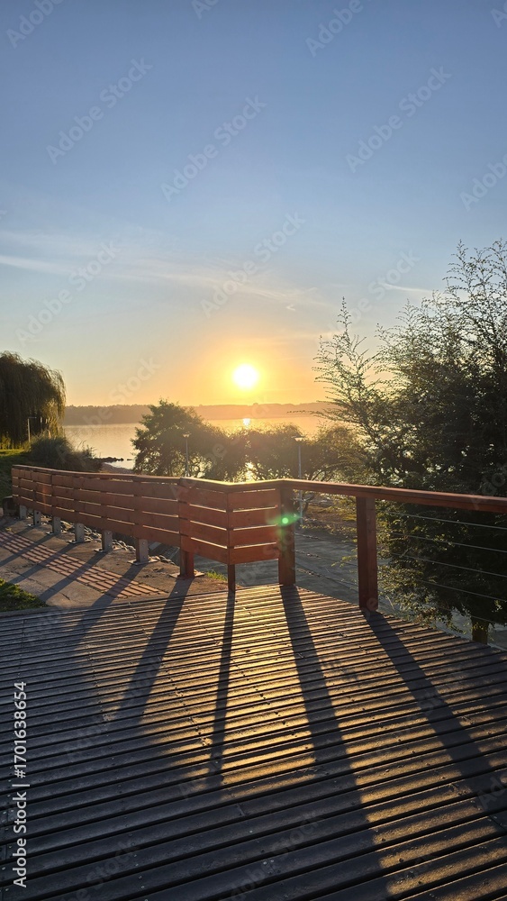 Fototapeta premium Golden sunset at Lago Ranco in southern Chile, with calm waters, mountains, and warm evening light creating a serene and picturesque landscape.