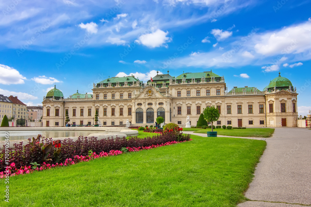 Obraz premium Historic Belvedere palace in Vienna with reflection in the water, green garden and blue sky.