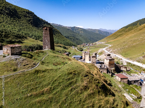 Svaneti towers rising from green valley in Mestia, Georgia, under blue sky