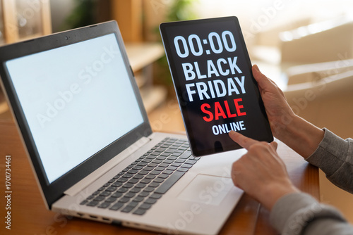Wall Mural Hands holding tablet displaying black friday online sale announcement next to la
