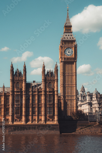 Majestic big ben clock tower against blue sky and white clouds, a symbol of london and england
