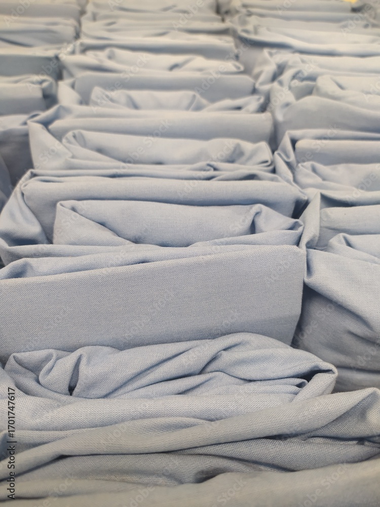 Fototapeta premium Stacks of Light Blue Fabric in Soft Folds Creating an Abstract Pattern