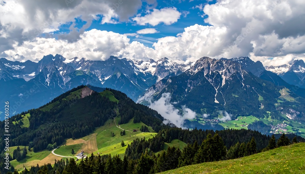 Fototapeta premium Lush green hills and meadows nestled within a breathtaking mountain range, bathed in sunlight, and crowned with snow-capped peaks.