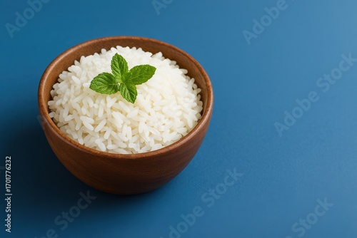 White Rice in Wooden Bowl with Mint on Blue Background