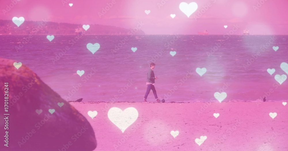 Obraz premium Walking male holding device along shore under pink heart overlays, with seabirds and mossy rock