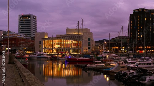 Bodo, Norway. View of the marina in the city center of Bodo, Norway with modern buildings at the background. Time-lapse at sunset. Panning video