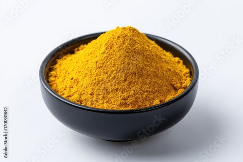 Fototapeta Naklejka Na Ścianę i Meble -  Pile of turmeric powder in a black bowl