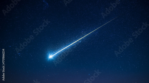 A brilliant meteor streak with a glowing tail in a star-filled night sky.