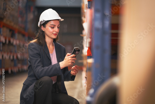 Foto Distribution warehouse worker using digital scanner checking inventory on shelf