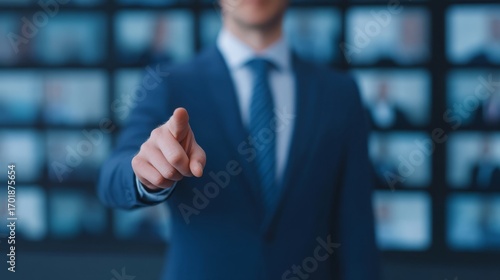 Wallpaper Mural A businessman in a suit points directly at the viewer, with blurred screens in the background displaying multiple people. Torontodigital.ca