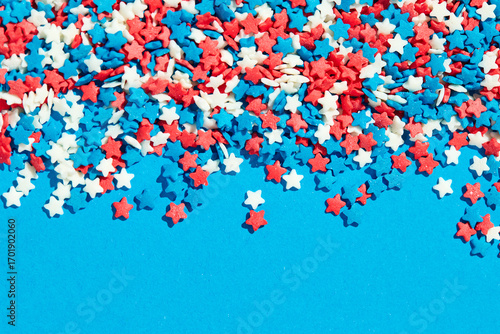 Colorful star shaped sugar sprinkles on blue background
