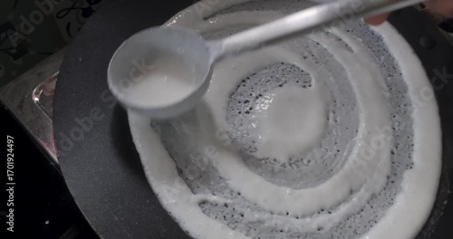 Dosa cooking on hot tawa, traditional South Indian breakfast dish made from fermented rice and lentil batter, crispy edges with soft texture