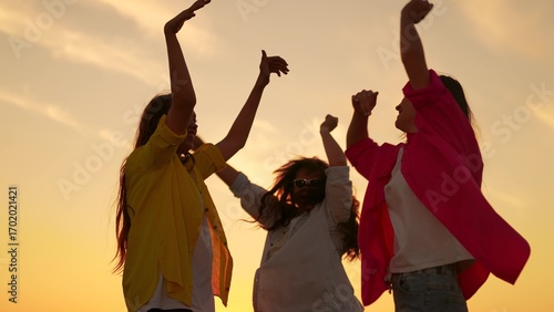 Foto People girls dancing to music at beach party raising hands up