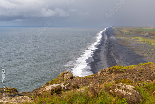 Bild auf Leinwand Plage de Solheimafjara, au sable noir volcanique, depuis le phare de Dyrhólaey,