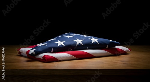 Veterans Day. National holiday of the USA. Soldier of USA. Folded American flag resting on a wooden surface against a dark background.