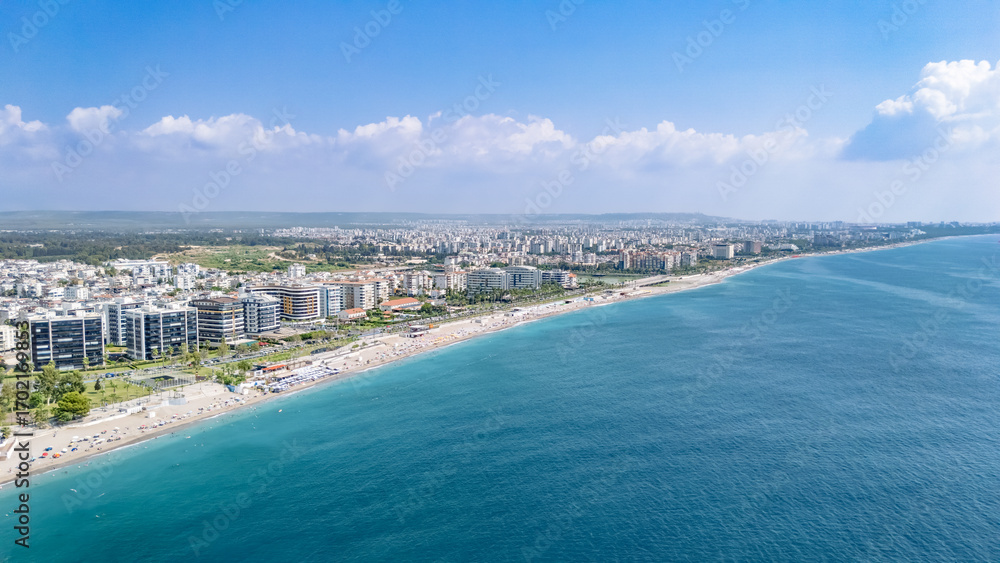 Obraz premium Aerial drone view of Antalya cityscape and Konyaalti beach, people sunbathing on sand, swimming in sea and relaxing, Antalya holiday vacation resort in Turkey
