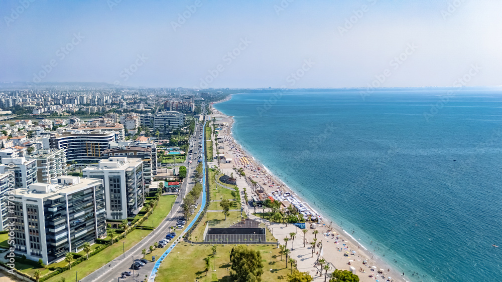 Fototapeta premium Aerial drone view of Antalya cityscape and Konyaalti beach, people sunbathing on sand, swimming in sea and relaxing, Antalya holiday vacation resort in Turkey
