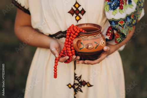 Photos A woman dressed in traditional Balkan style, wearing colorful garments with delicate embroidery and authentic ornaments that reflect the cultural identity of the region