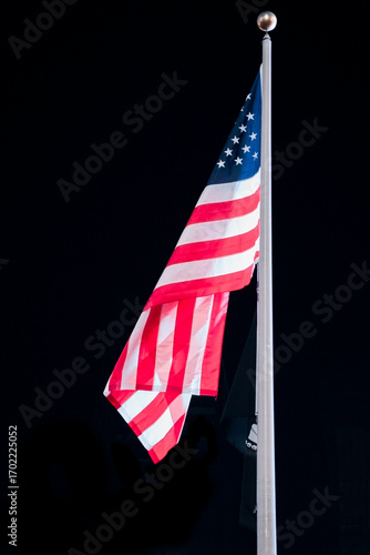 Flag of the United States of America on a flagpole at night