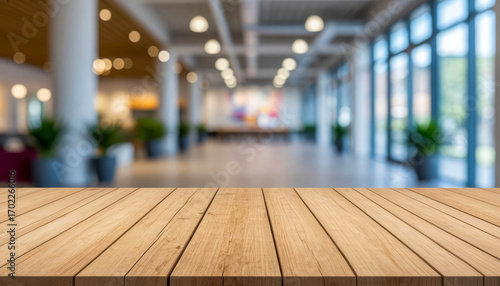 Brown wooden table surface in foreground on blurred, out of focus room interior background.