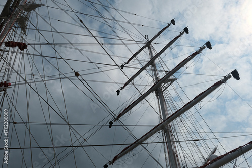 masts of a sailing ship against a sky with clouds