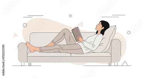 Woman Comfortably Reclines on a Couch While Reading a Book for Relaxation