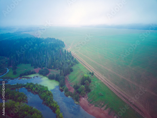 Aerial view landscape on foggy morning in countryside with lake and forest


