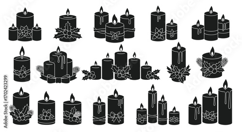 Collection of festive decorative candles with floral accents and lit flames for seasonal celebrations