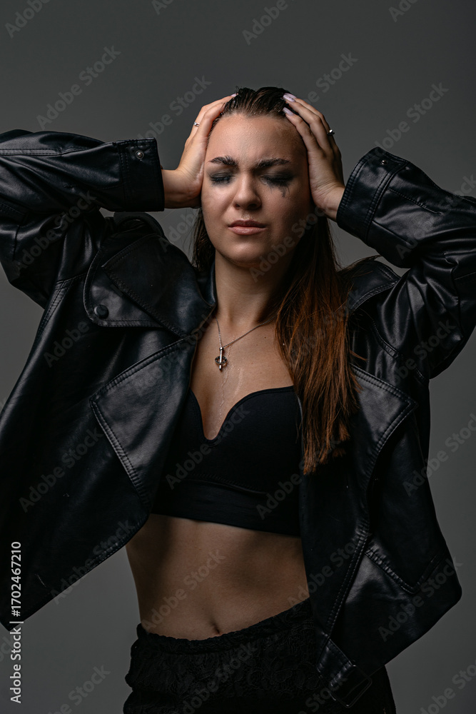 Naklejka premium Model expressing intense emotion in a dark studio setting with dramatic lighting