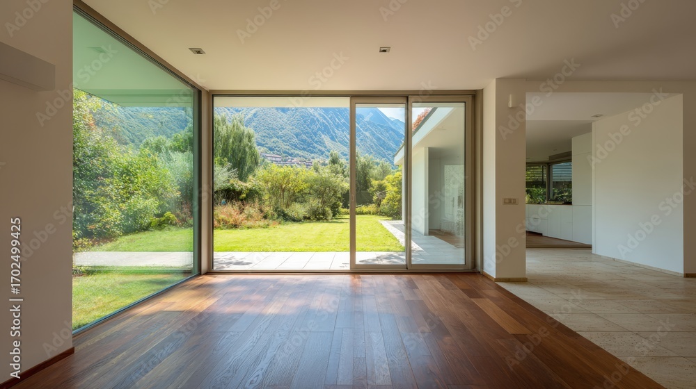 Obraz premium Bright Modern Interior with Expansive Windows Overlooking Lush Green Garden and Distant Mountain Range