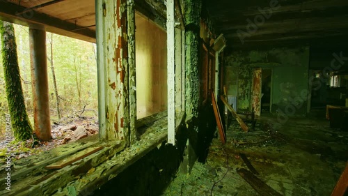 An eerie and poignant view inside a dilapidated classroom of an abandoned school in Pripyat, Ukraine, within the Chernobyl Exclusion Zone. Peeling paint, broken windows, and decaying furniture evoke t
