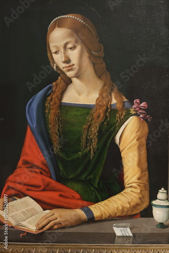 Slika na platnu A Renaissance painting of a serene woman with long wavy hair, wearing colourful robes, a pearl headband, and holding an open book, symbolising devotion and wisdom